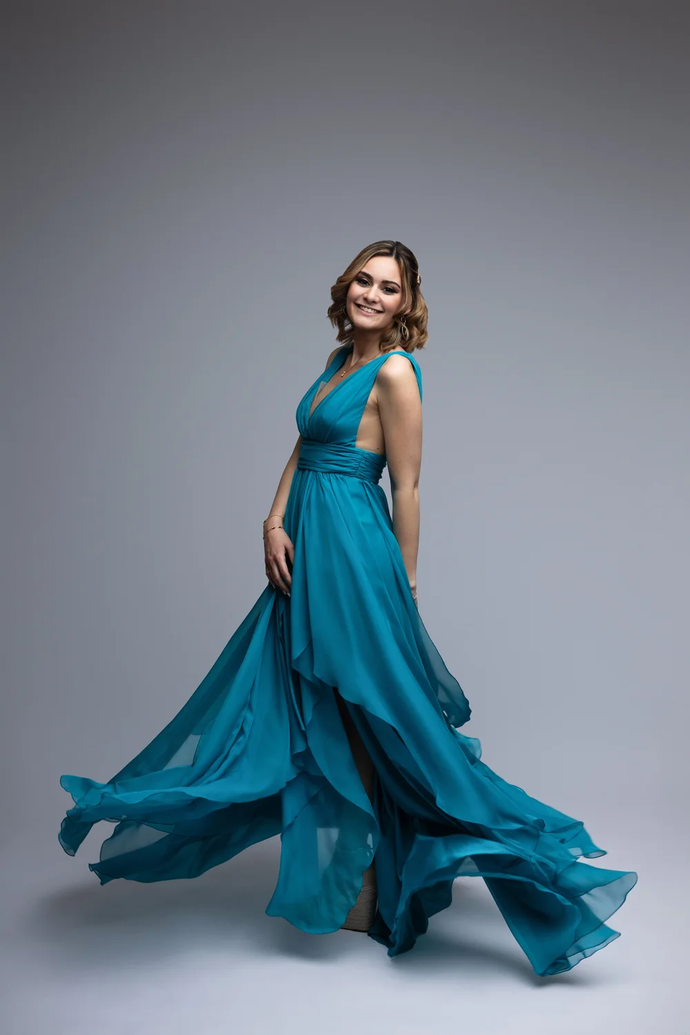 Femme en robe bleue qui vole, en studio.