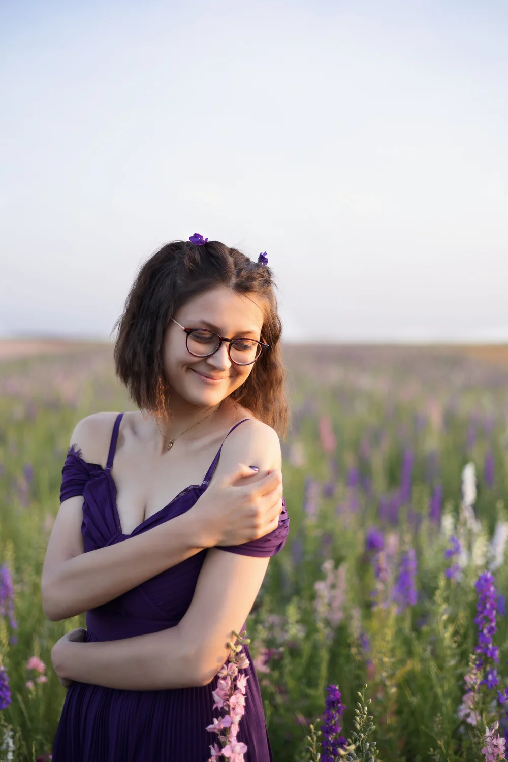 Femme en robe violette dans un champ de fleurs.