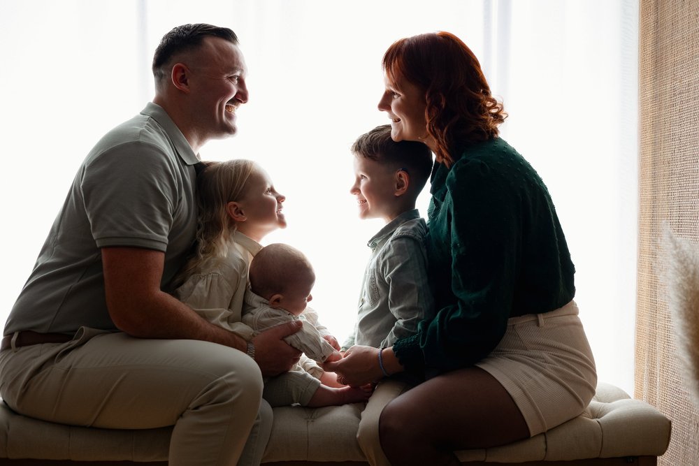 Parents et leurs enfants assis en contre-jour dans le studio.