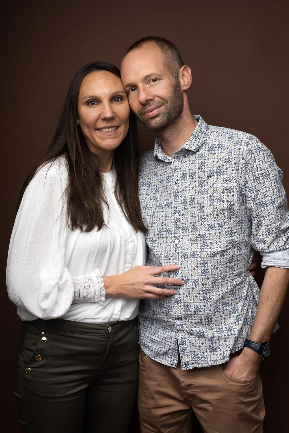 Couple en studio, sur fond brun.