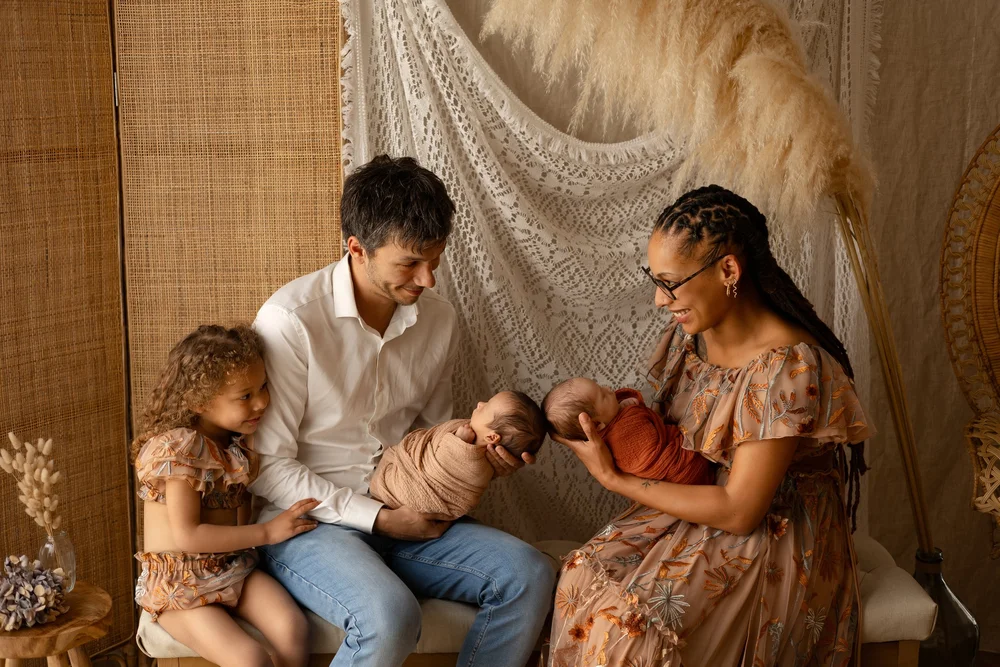 Famille en studio devant un paravent, le nouveau-né au centre.