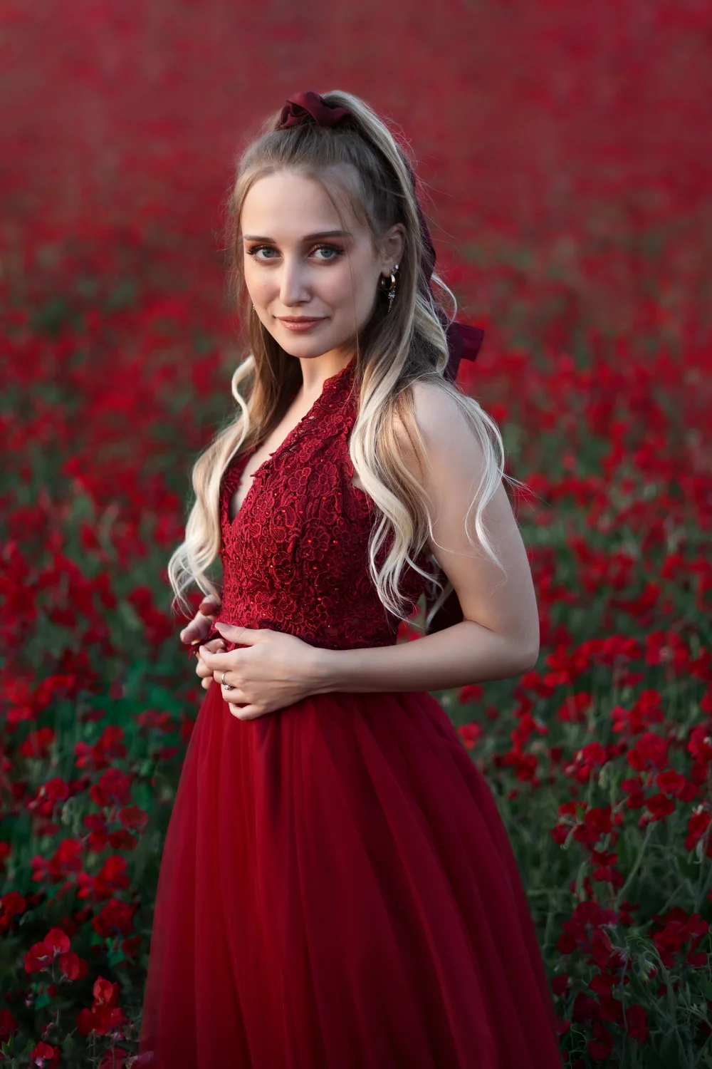 blonde aux yeux bleus robe de princesse rouge dans les fleurs