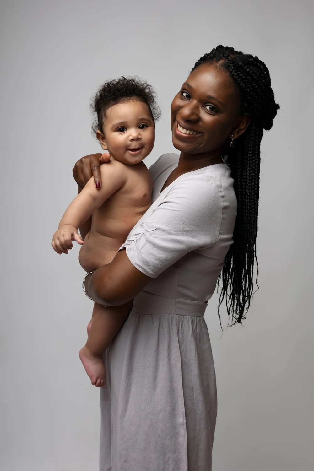 Maman tenant son bébé contre elle, sur fond clair.