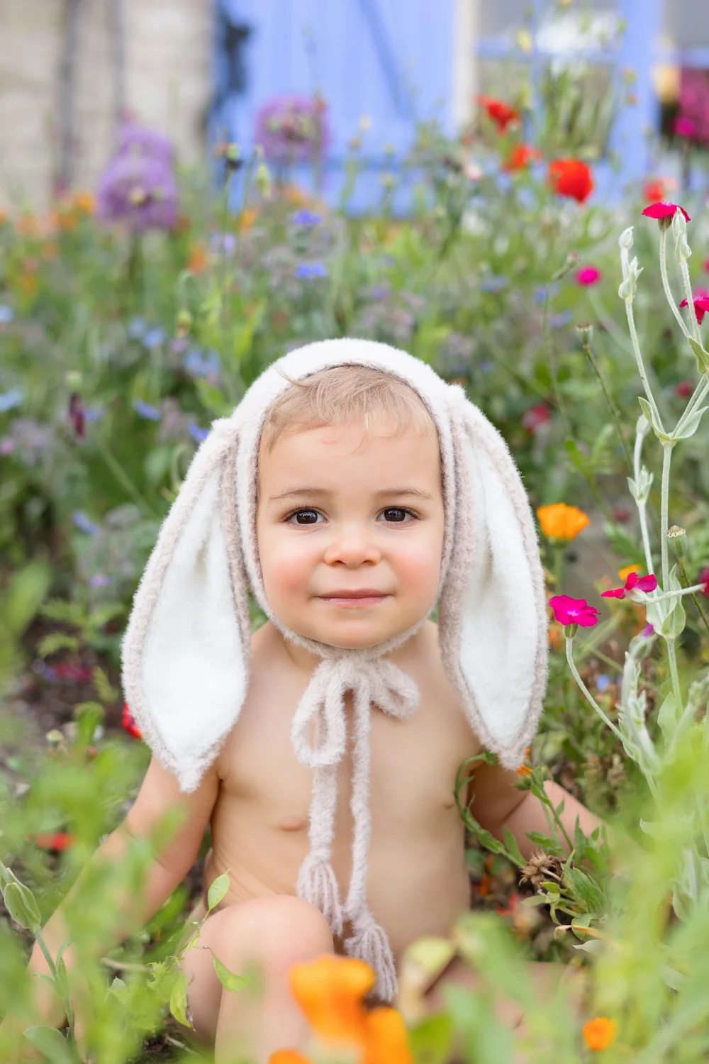 petit garçon bonnet oreilles lapin dans les fleurs