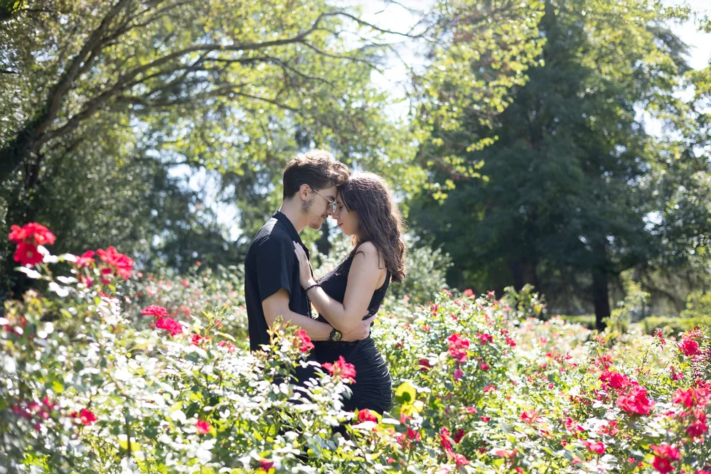 Couple enlacé dans une roseraie.
