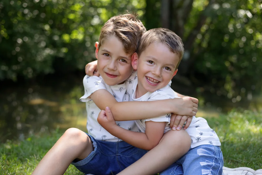 Deux frères enlacés dans l’herbe.