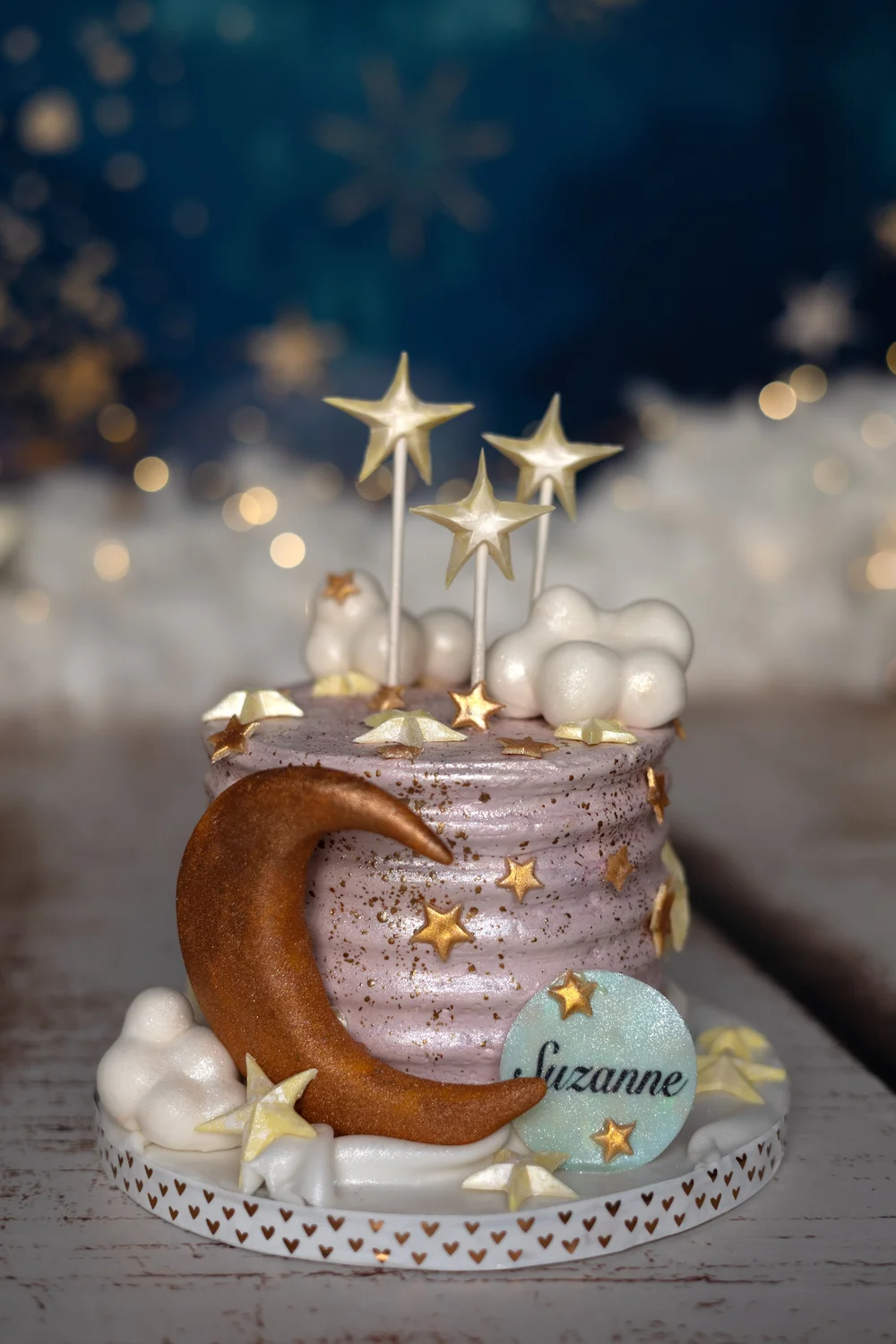 Gâteau lune et étoiles devant un décor de nuages.