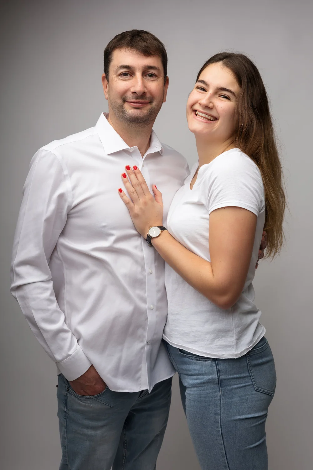 Couple en studio, sur fond gris.