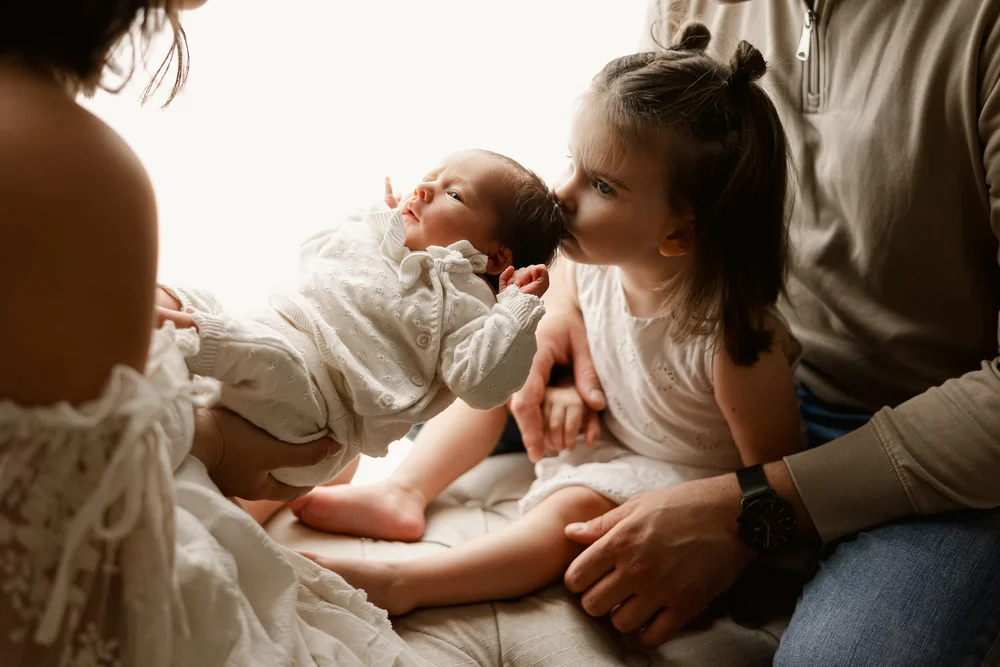 Famille allongée sur un lit avec leurs deux enfants.