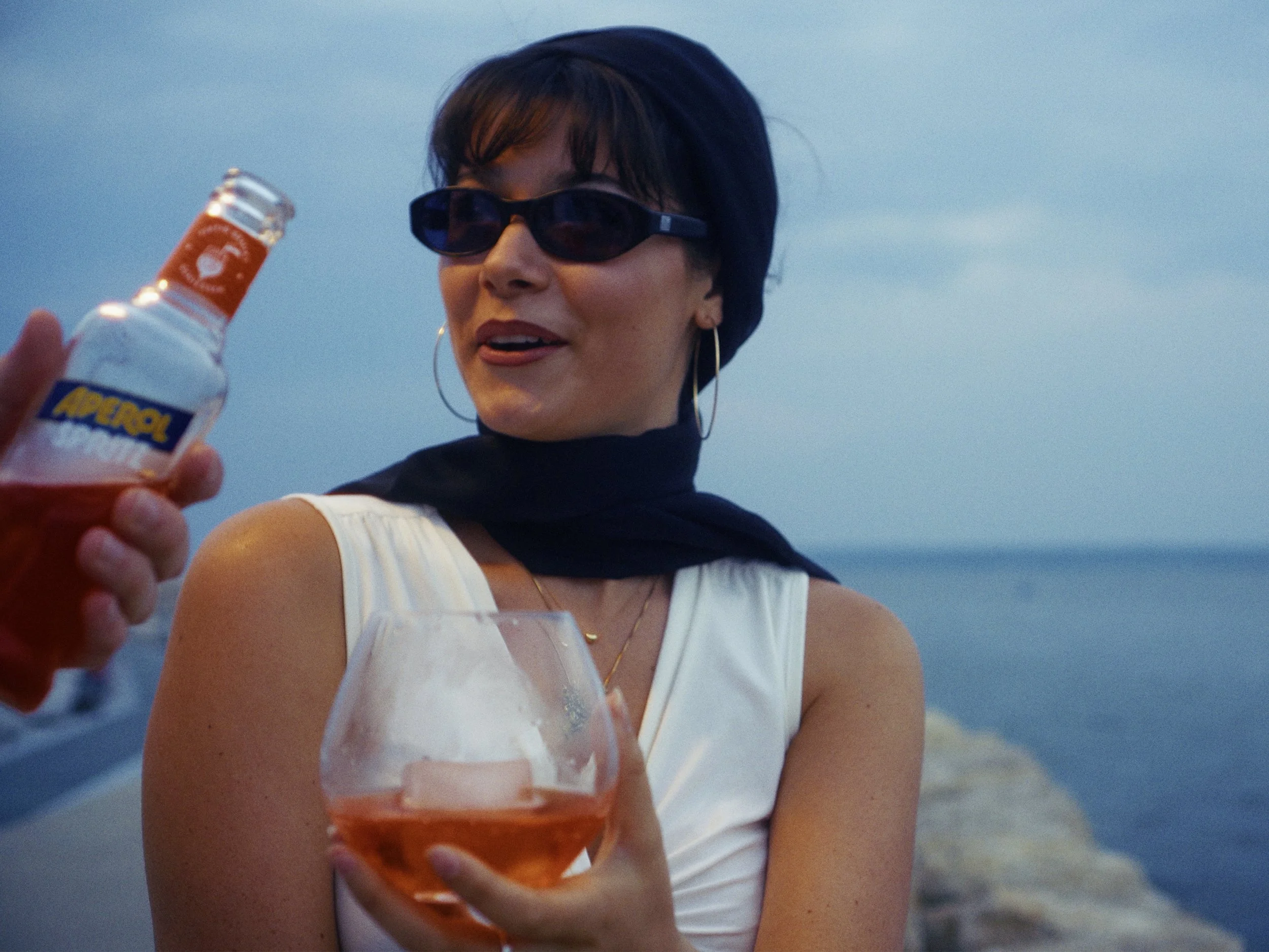 As my sister continues her journey within marketing, her next project centers around the romantic cinematic approach of the 70’s. A lonely woman by the sea, romanced by a bold stranger for a glass of Aperol. A drink neither of them can pronounce prop