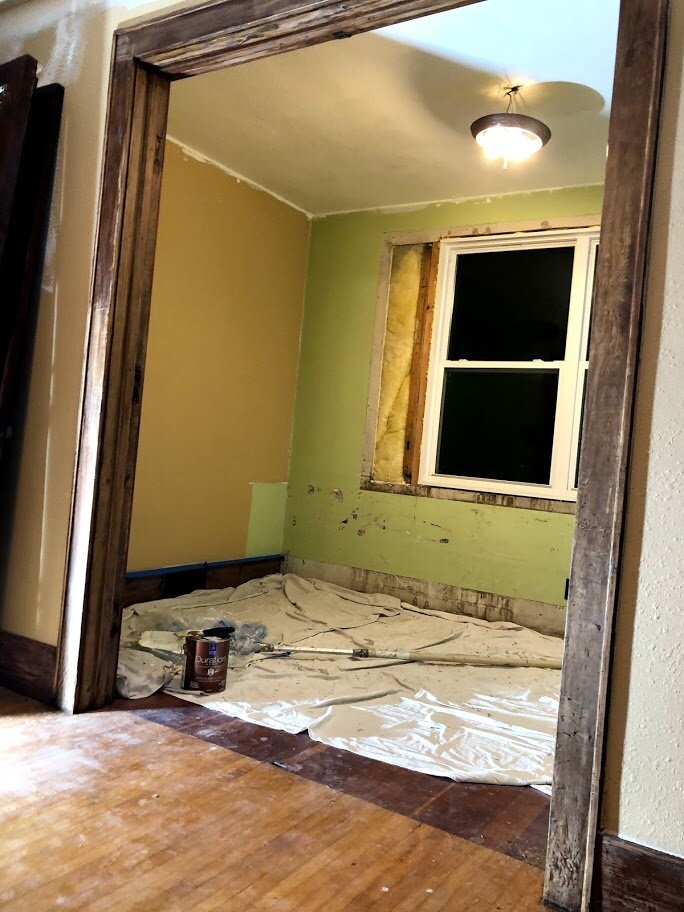 Built-ins and paneling have been removed from the front room and the ceiling has been painted.