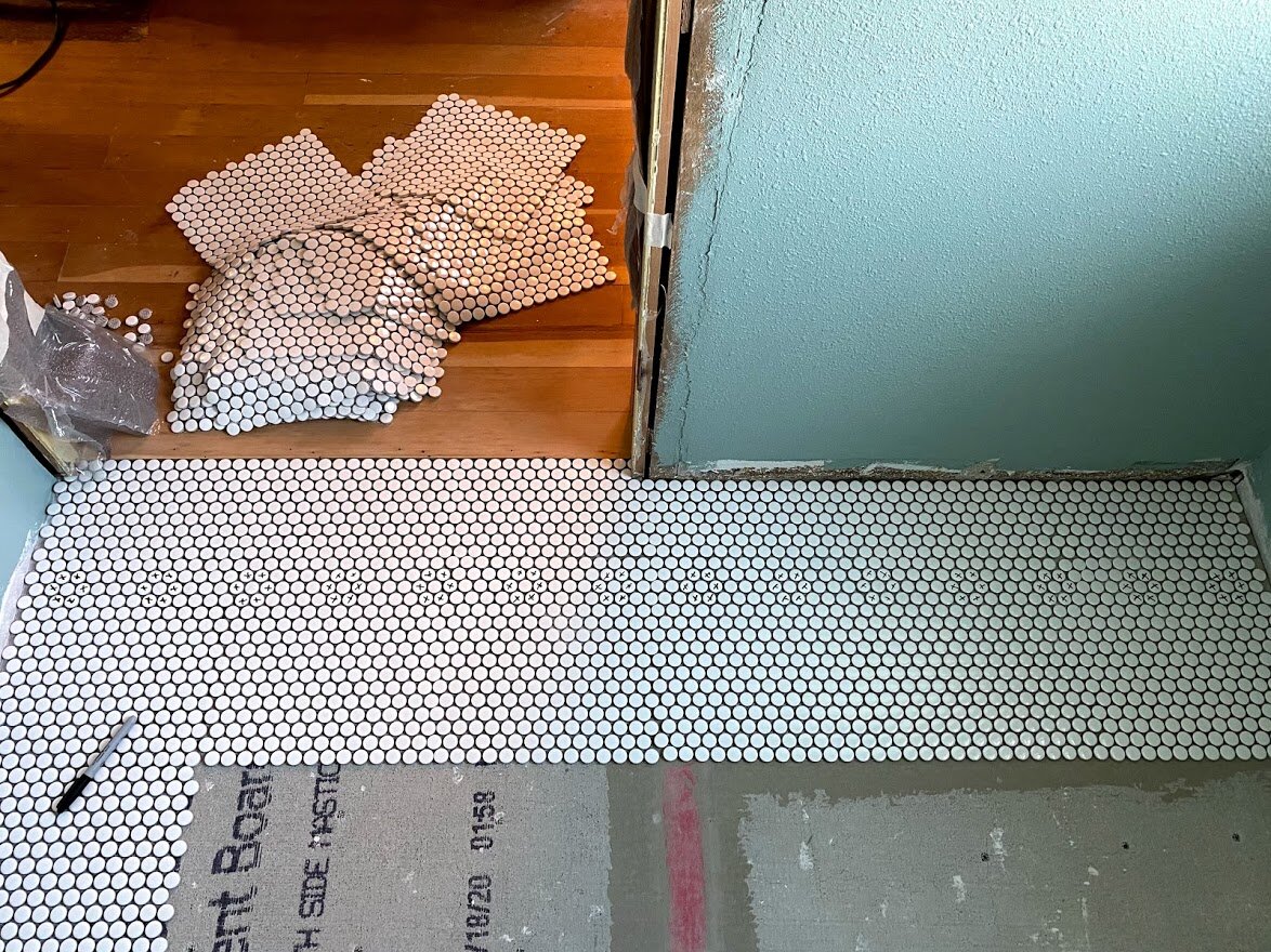 What I do when everyone has gone home.... I marked the tiles for the border. The next day, Jerod plucked them out and I handed him black ones to create a flower border.