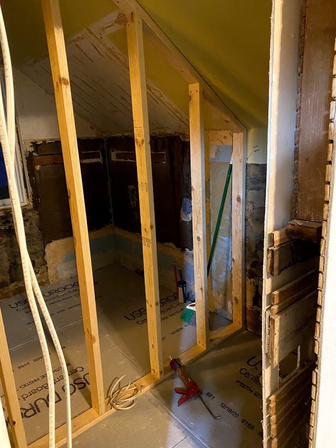 A new wall divides the old bathroom into the new laundry room and toilet room.