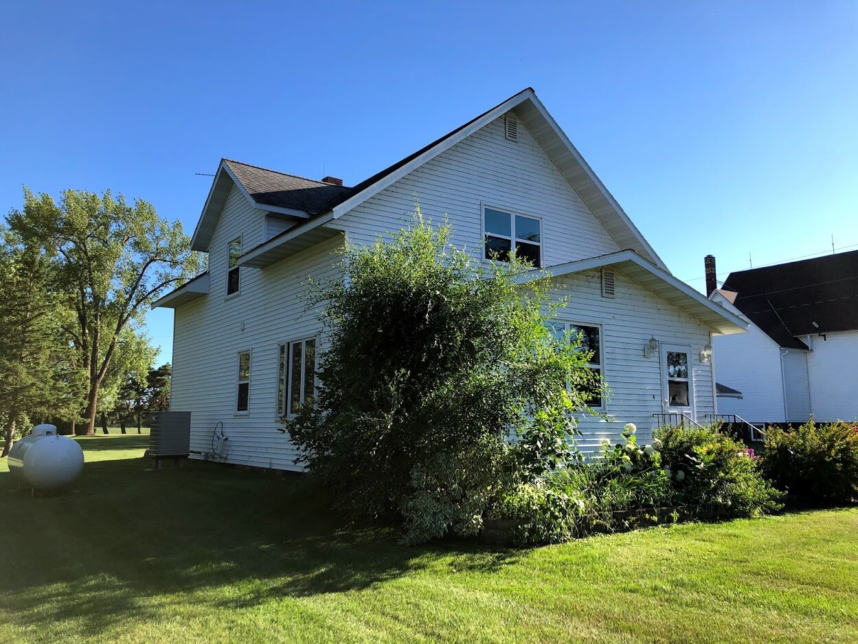 The first image of the house. There were several overgrown saplings and trees growing in the planters in front of the house.