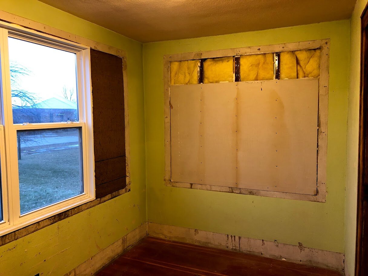Front room after the paneling was removed. There used to be a window on the east side as well.