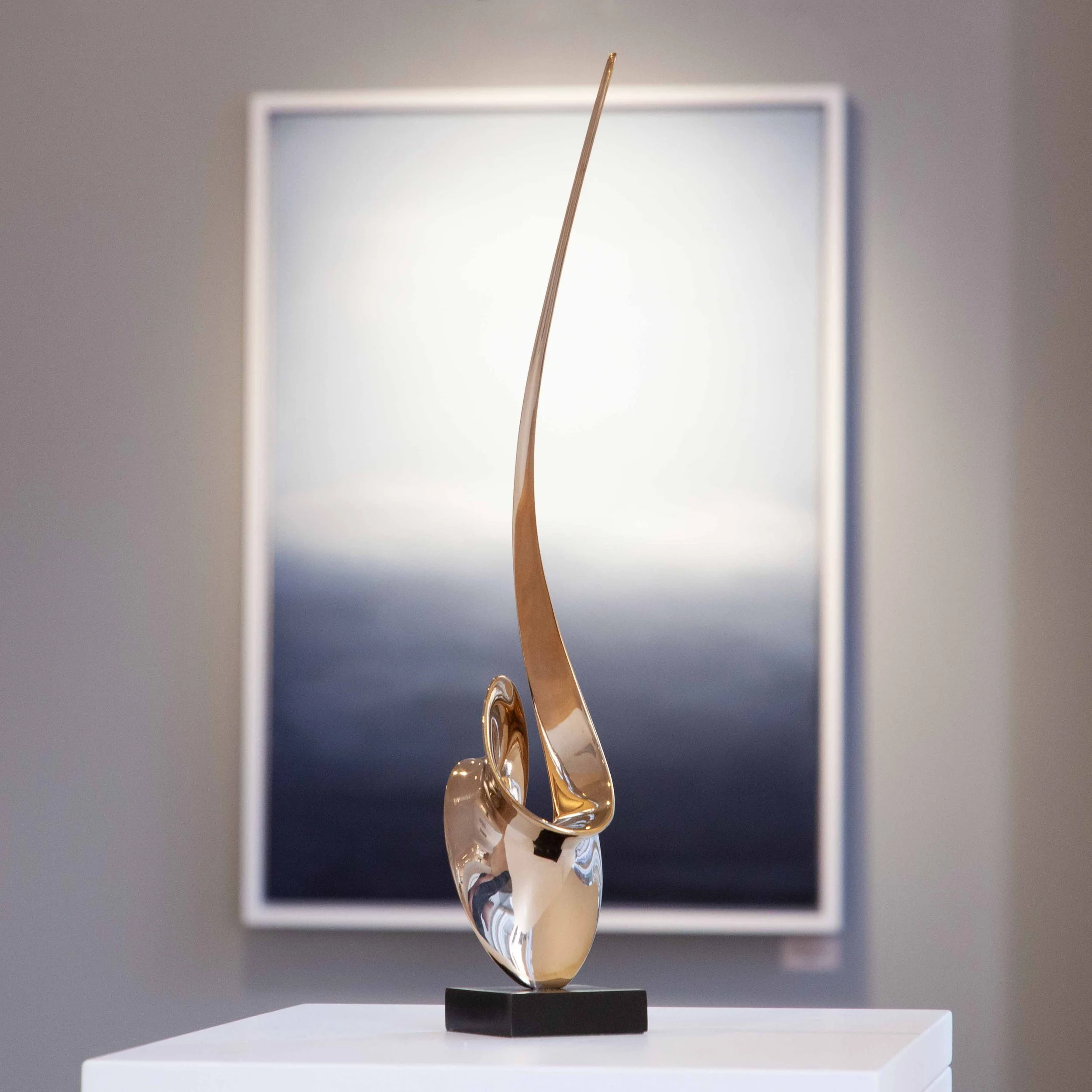Polished bronze contemporary sculpture by West Sussex, English artist and sculptor Hugh Chapman the work is collected by art collectors for their art collections. Hugh Chapman's contemporary polished bronze sculpture sits in an art gallery