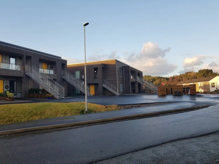 Moderne rekkehus med utvendige trapper på en overskyet dag.