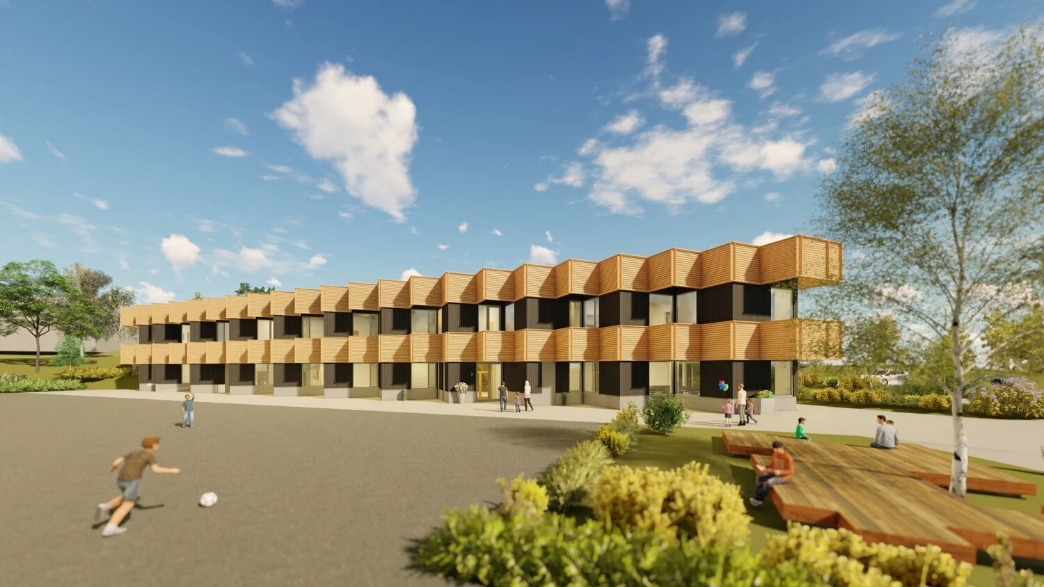 Moderne bygning med trepaneler og glass, omgitt av landskap og trær. Flere personer, inkludert barn som spiller fotball, kan sees i uteområdet, og noen sitter på trebenker. Solfylt dag.