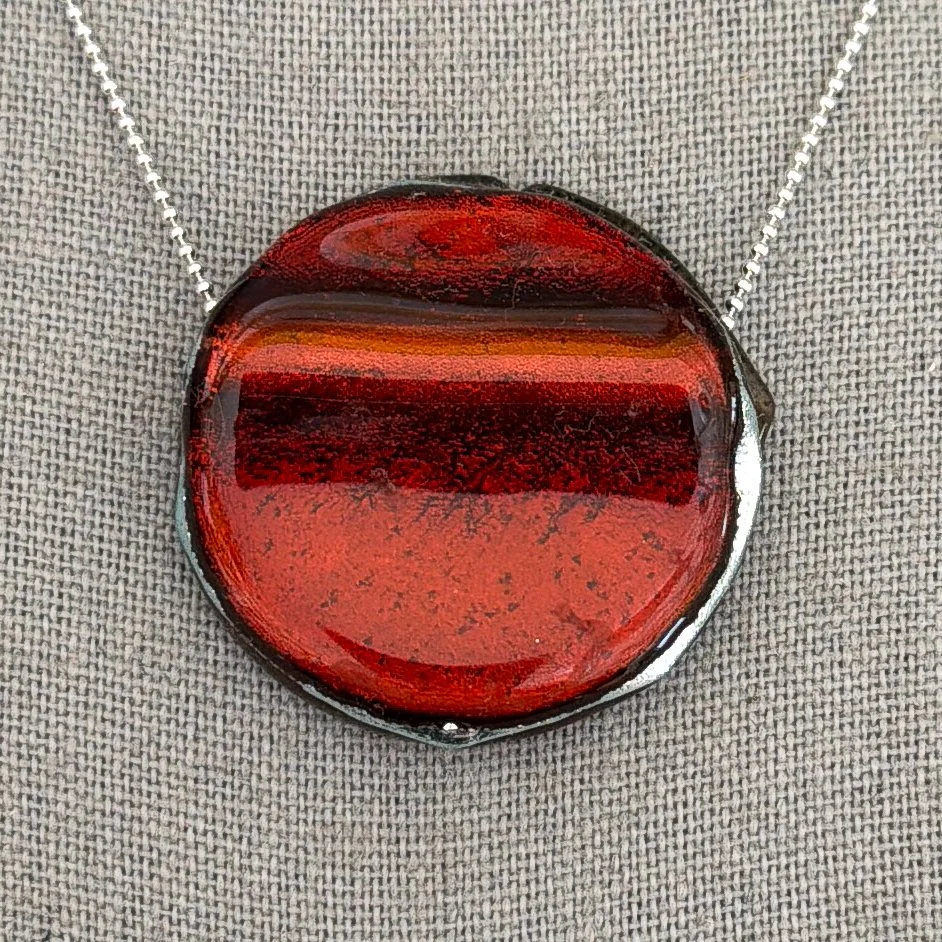 Burnished round deep red fused dichroic glass stone necklace on sterling silver chain with copper shimmer.