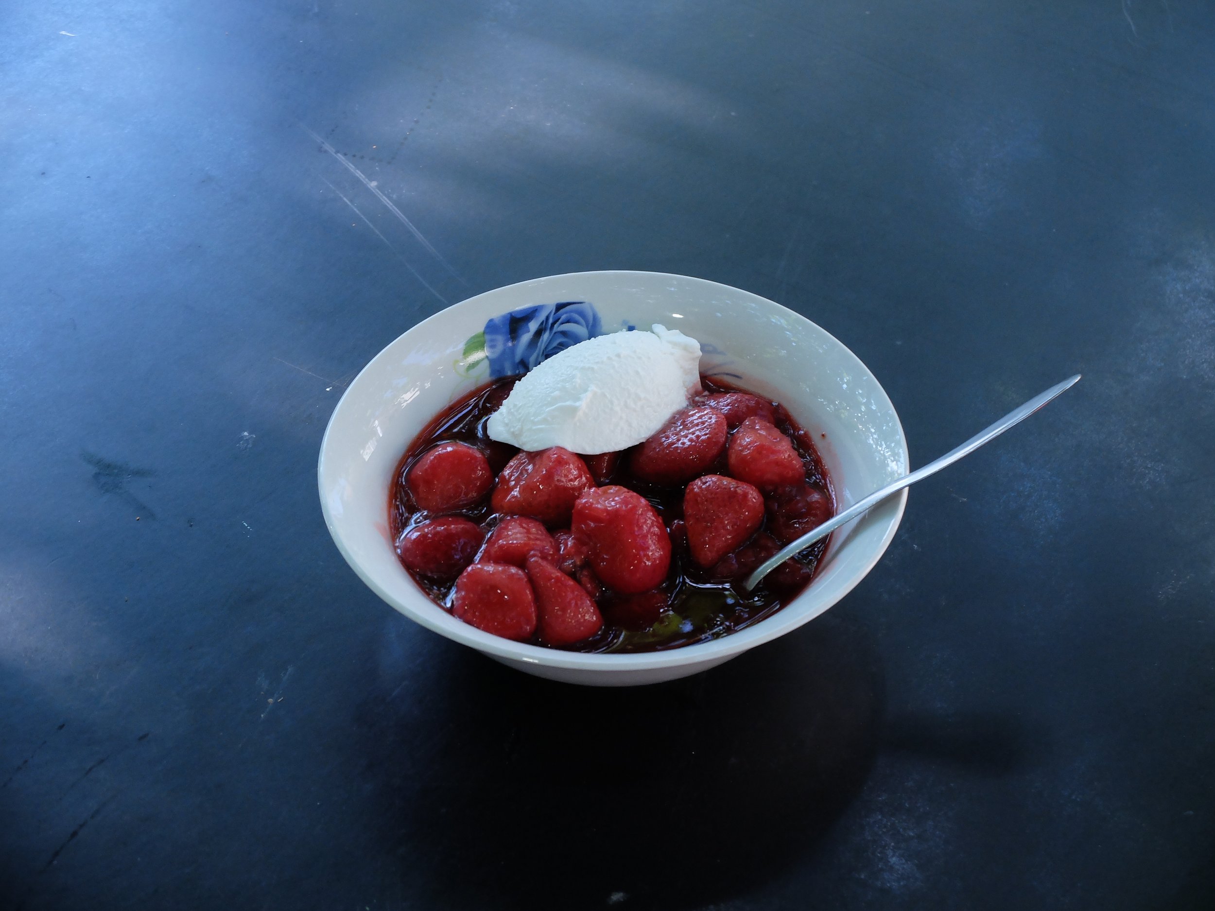   Lone Haugaard Madsen, Recipe: Fresh strawberries cooked with sugar eaten warm with cold cream on a plate with a blue drawing, ceramic bowl with a blue rose from baba Vasa's kitchen, cooked by Laurenz  