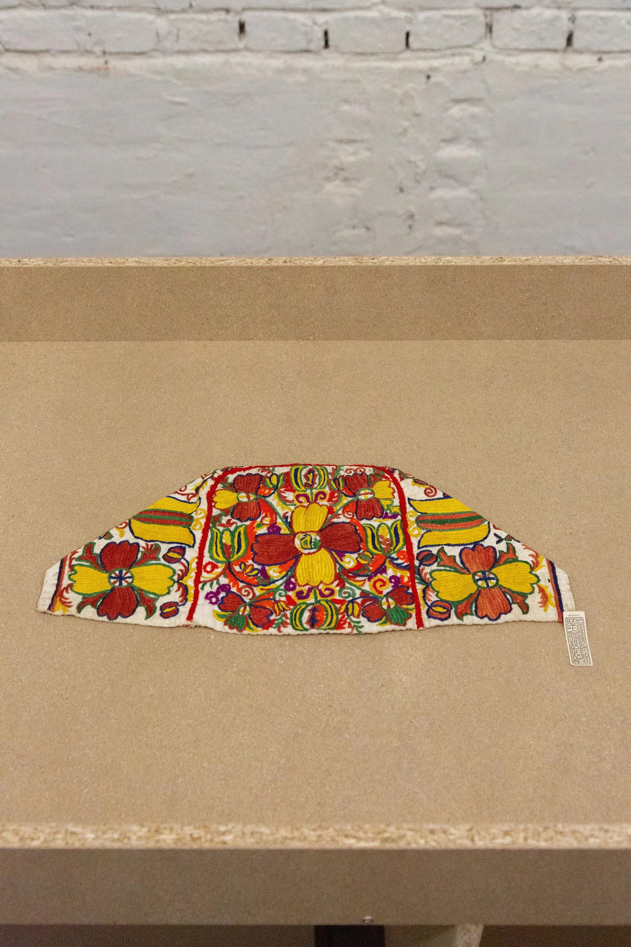   fig16  unknown artist, Schule / School Rosalia Rothansl,  Bodenhaube, Lehrmittel / Bonnet, teaching material,  1909 - 1911, Cotton, embroidered, 18 × 41 × 0,5 cm, On loan from the Collection and Archive, University of Applied Arts Vienna 