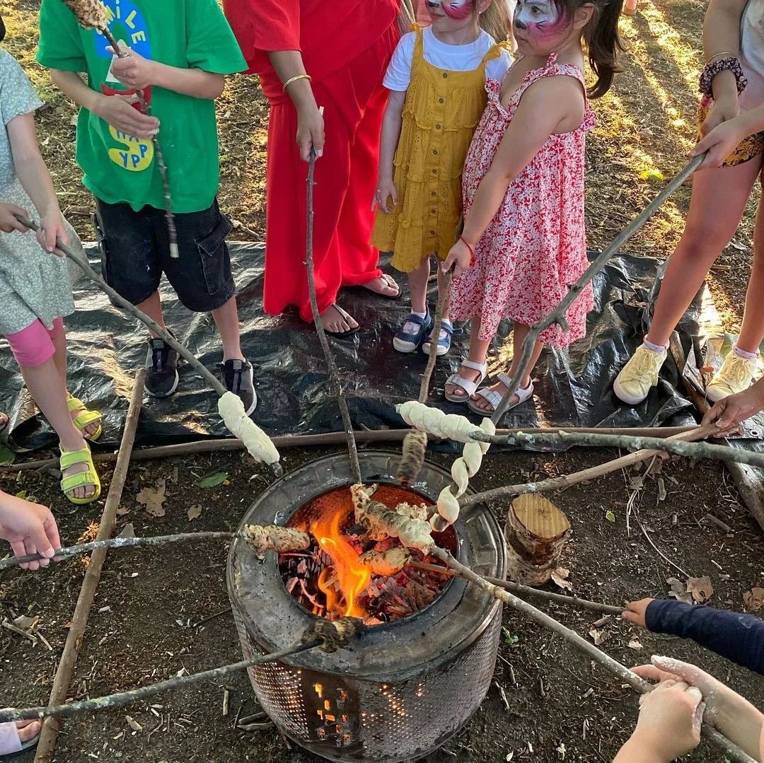 Children roasting marshmallows around a campfire outdoors