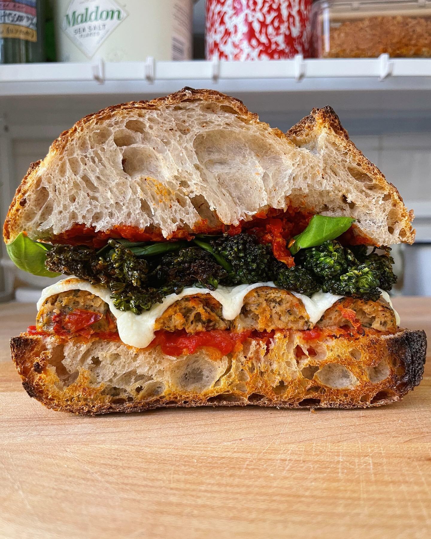 @eatseemore CHICKEN PARM SAUSAGE SANDWICH 🥳 with tomato butter sauce, broiled mozzarella and parmesan, crispy broccolini, @squarerootsgrow basil, and a big spread of chopped calabrian chilis between two slices of sourdough ❤️ I shocked even myself w