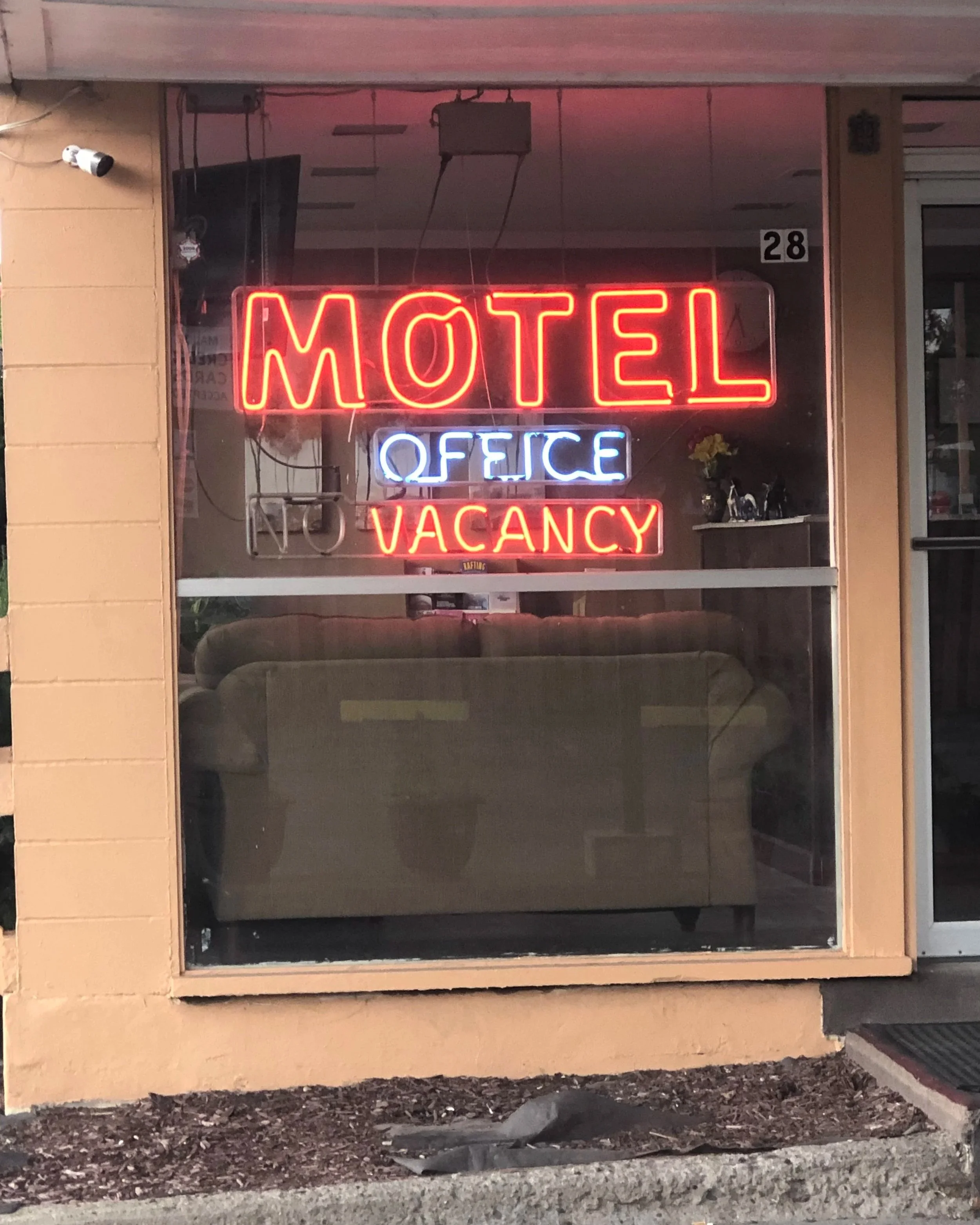 Neon sign in window reading Motel and Vacancy