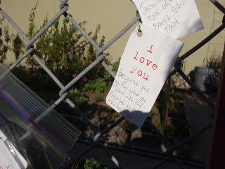 "i love you" cards on the fence at Growing Home Community Garden Project