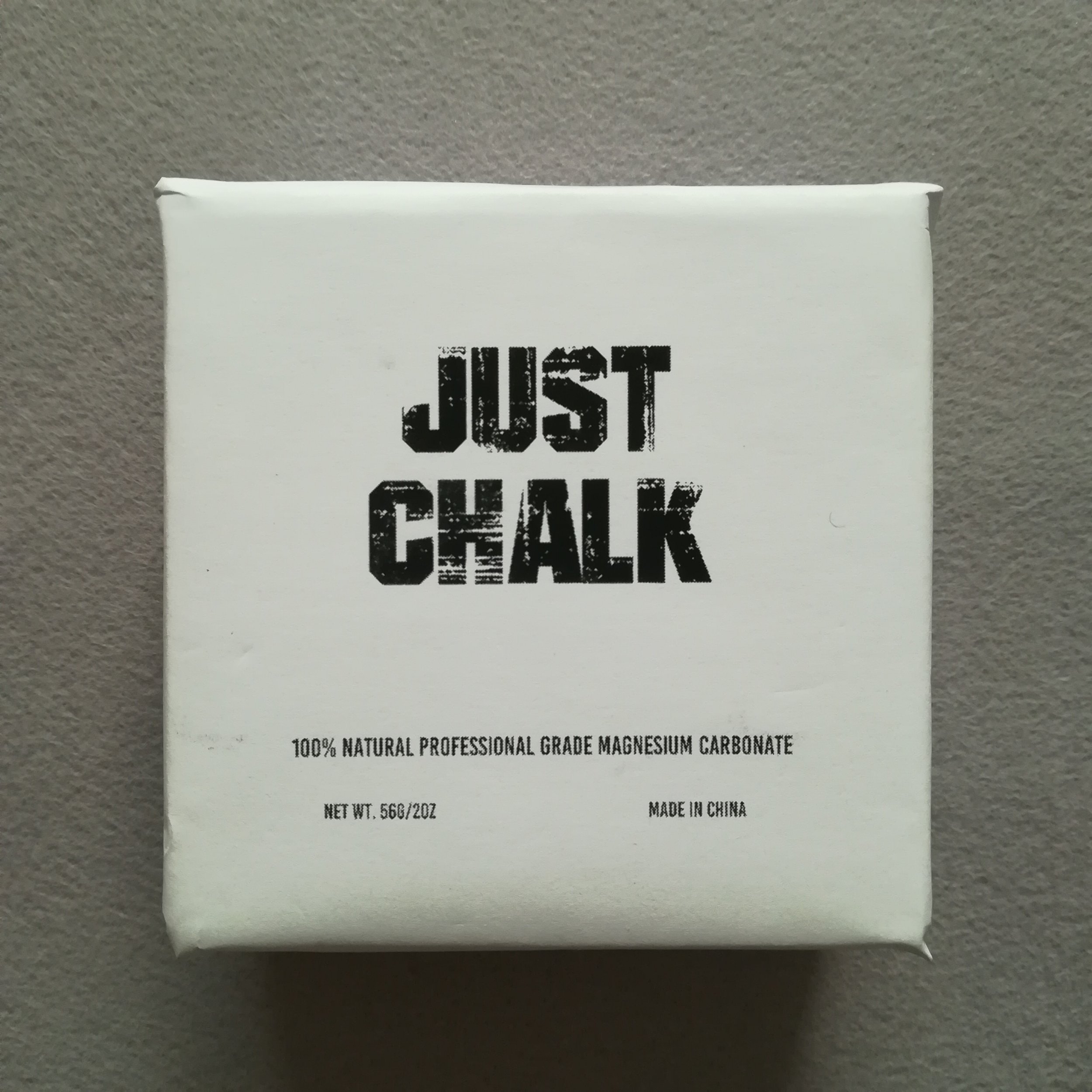 White magnesium carbonate chalk block resting next to gymnastics grips for Murph workout