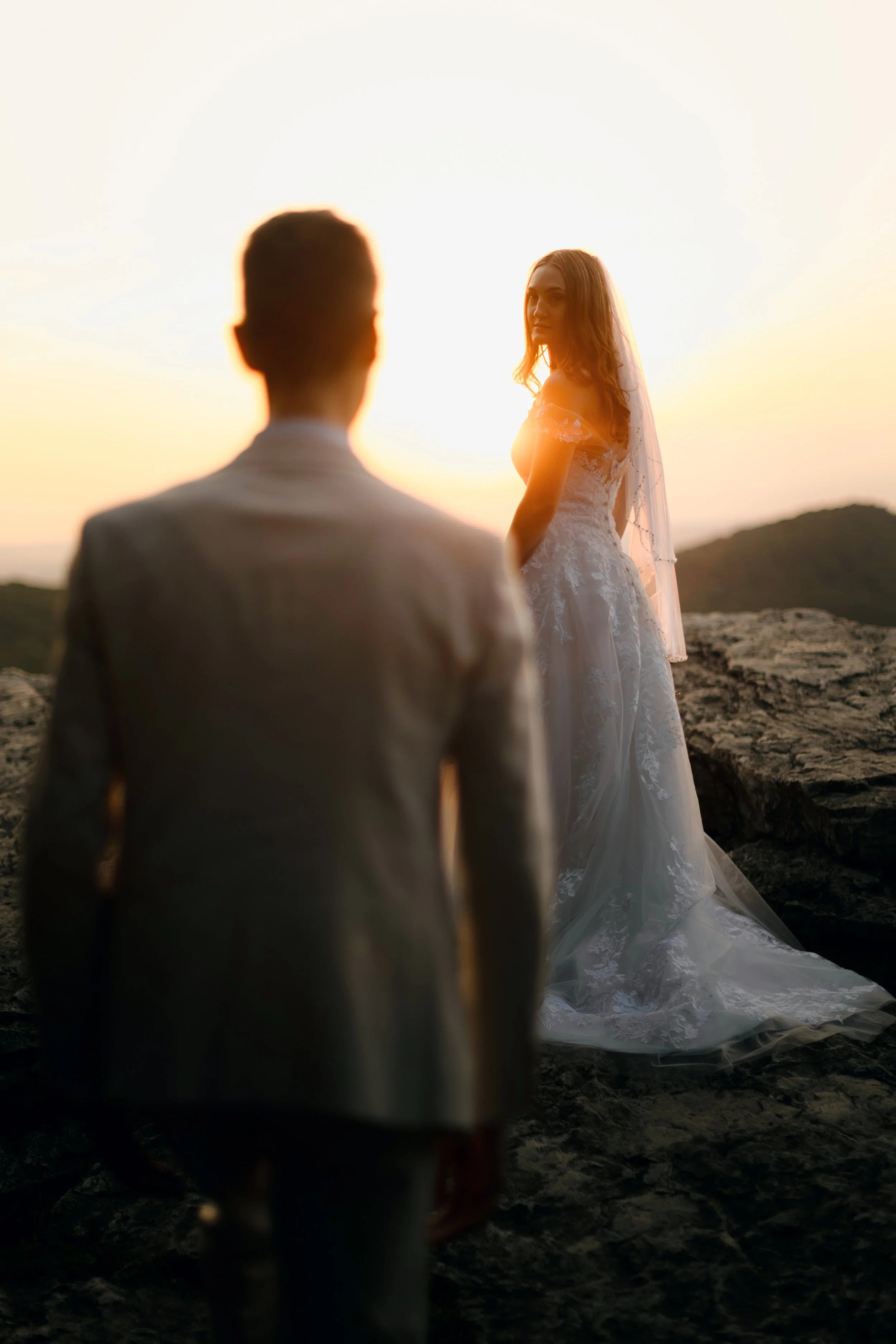 Bride and groom smiling illuminated by golden morning sunlight during a Pennsylvania mountain elopement portrait
