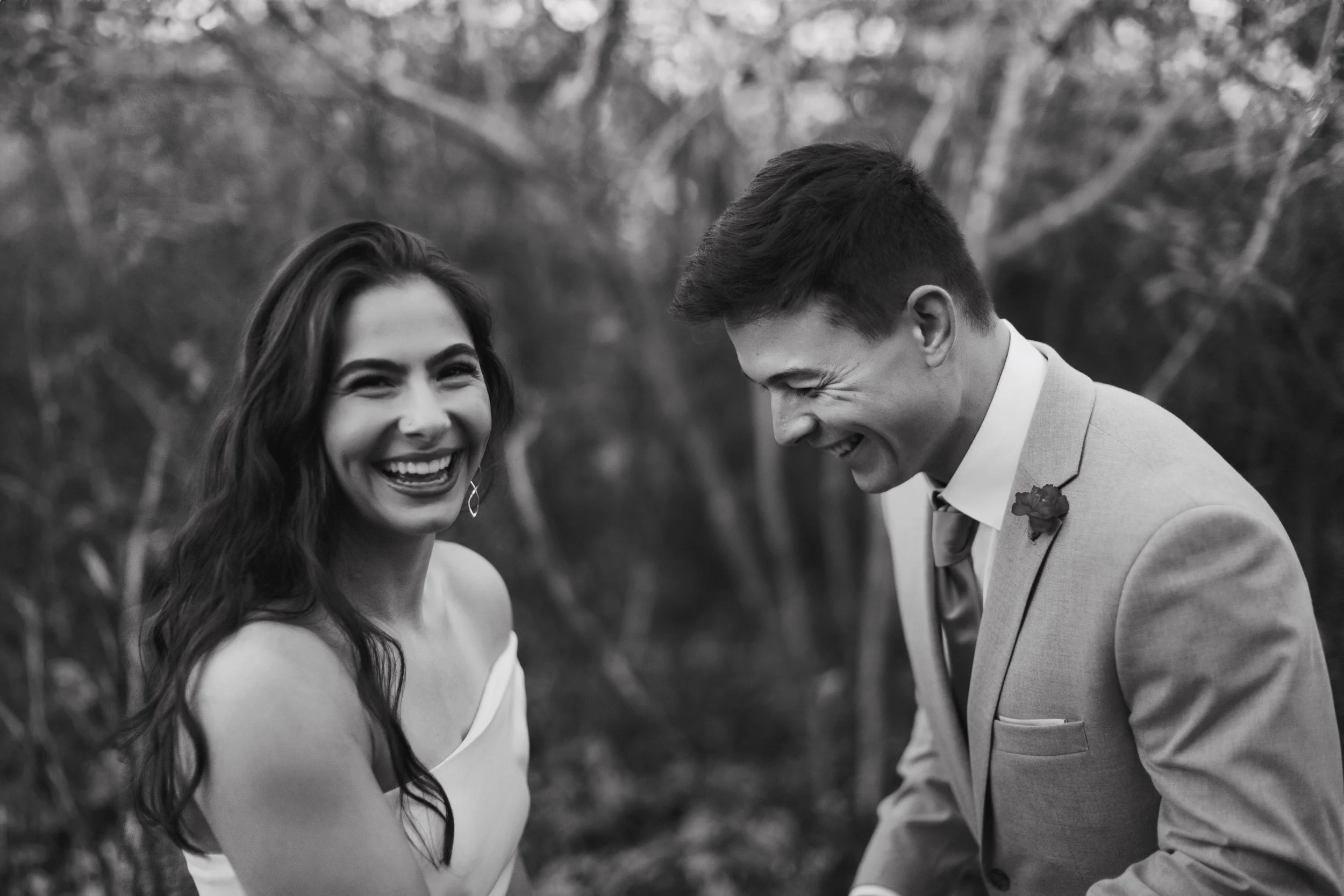 Candid black and white elopement portrait in Lancaster, PA; bride and groom laughing together during an intimate outdoor ceremony.