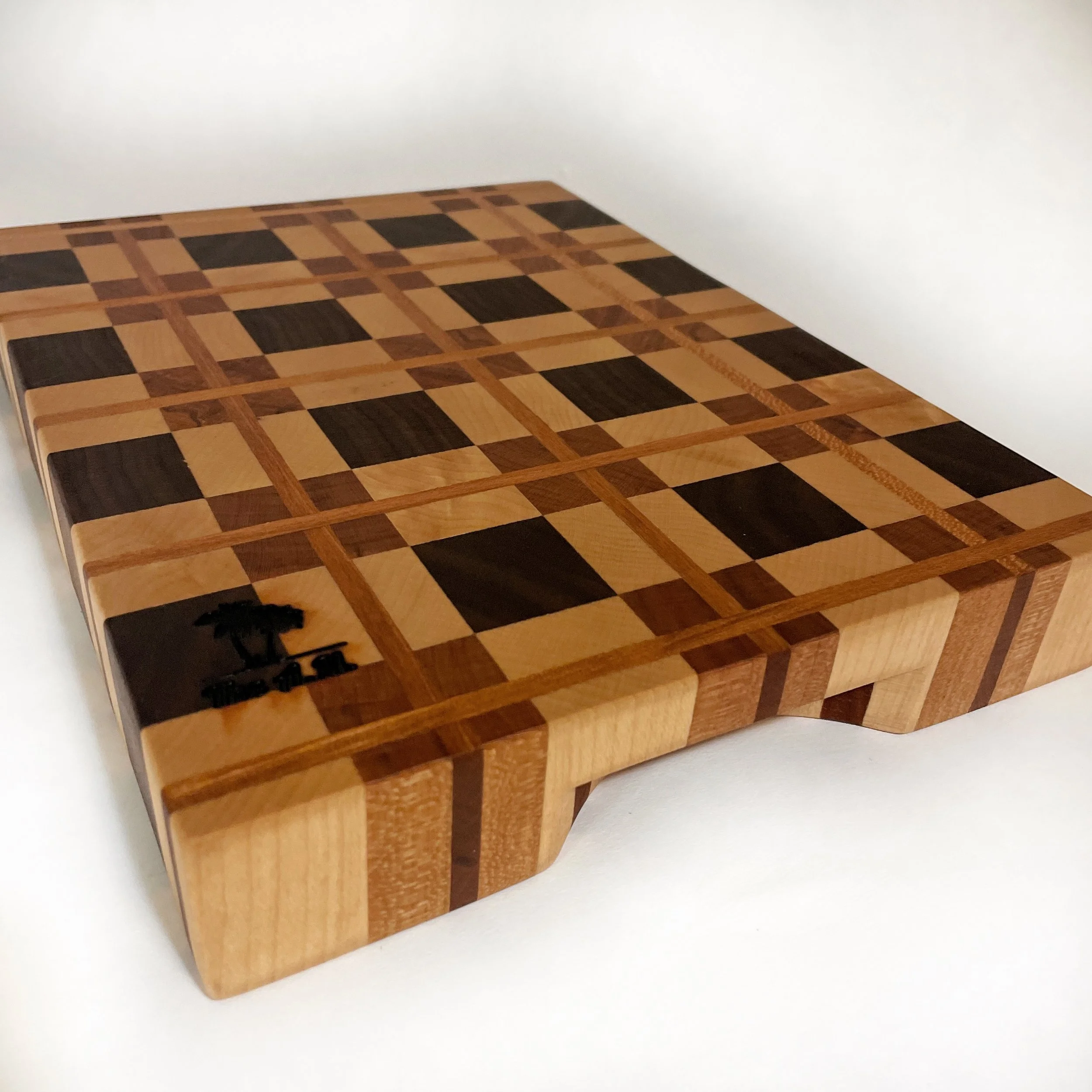 Compact Arden Noble hardwood cutting board featuring geometric plaid design in maple cherry and walnut