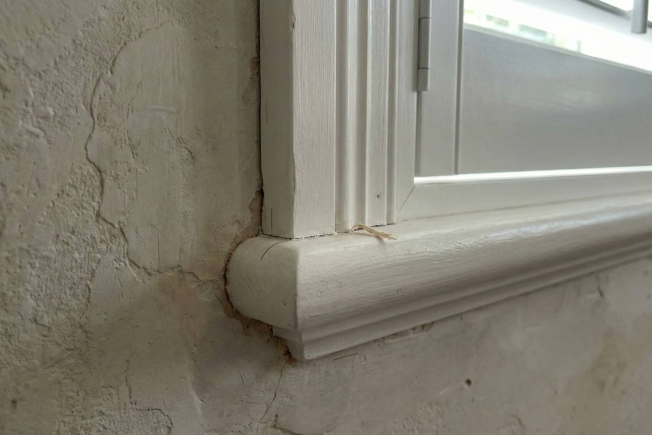 Close up of a scribed shutter frame against an uneven wall