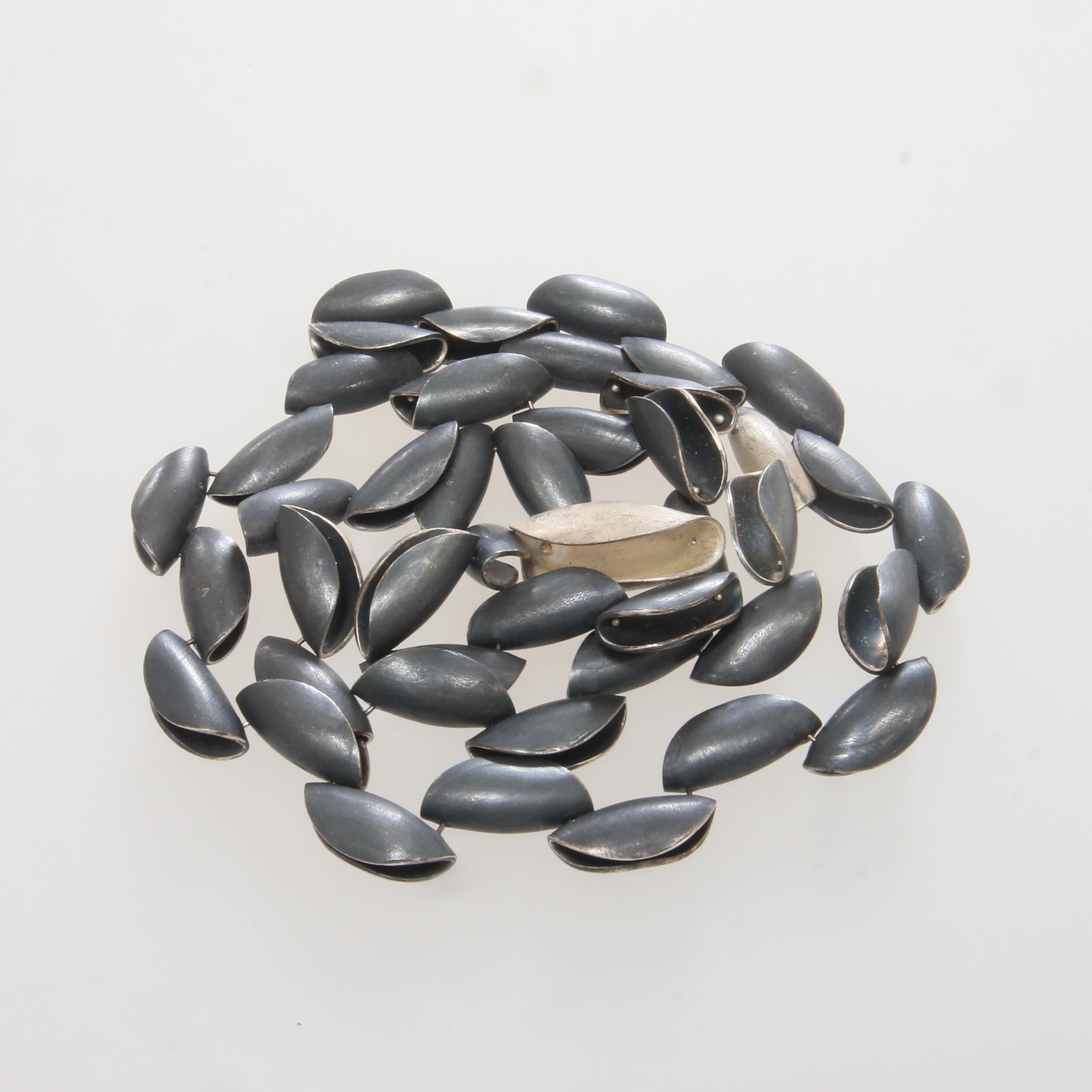 This is one of my seed necklaces, here in oxidised silver. It has the most lovely do-er upper- clasp,which makes me love it more!  It sits about collar nine length on me -about 48cm long. It looks fine coiled up too. 
#silverjewellery #seeds #rivets 