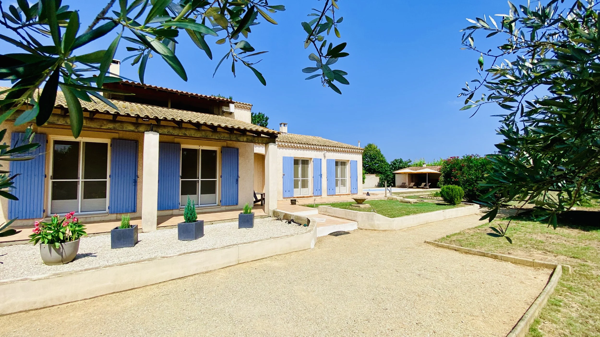Provence-style villa with blue shutters surrounded by garden at Villa Magali Arles