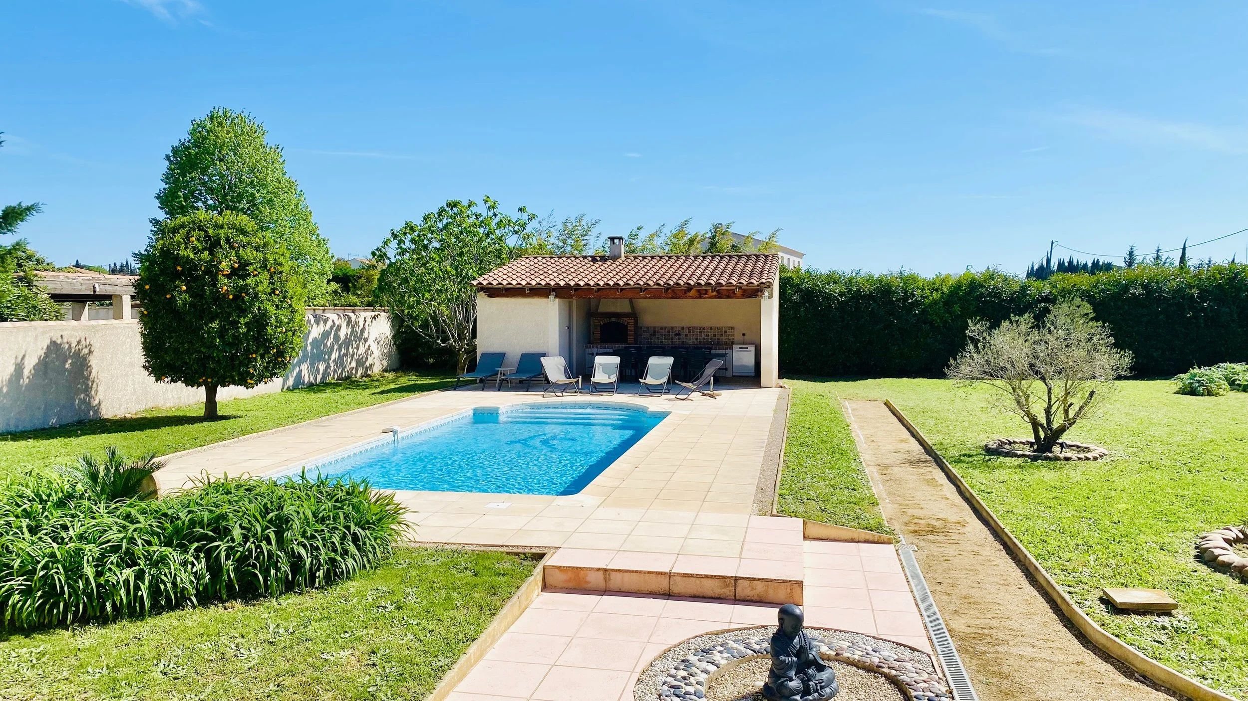 Swimming pool and outdoor kitchen area in the garden at Villa Magali Arles