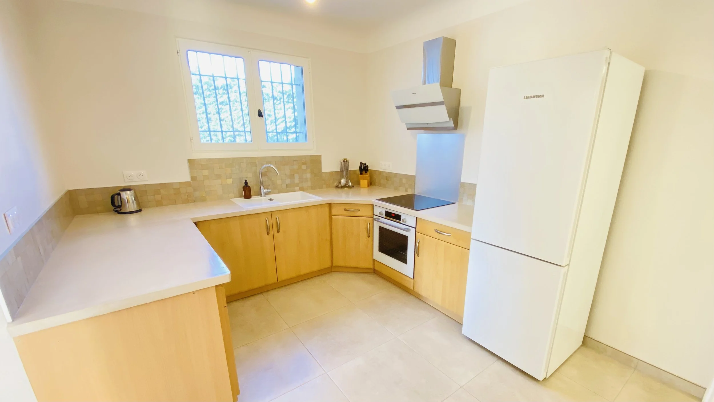 Fully equipped modern kitchen with oven, induction cooktop and fridge at Villa Magali Arles in Provence