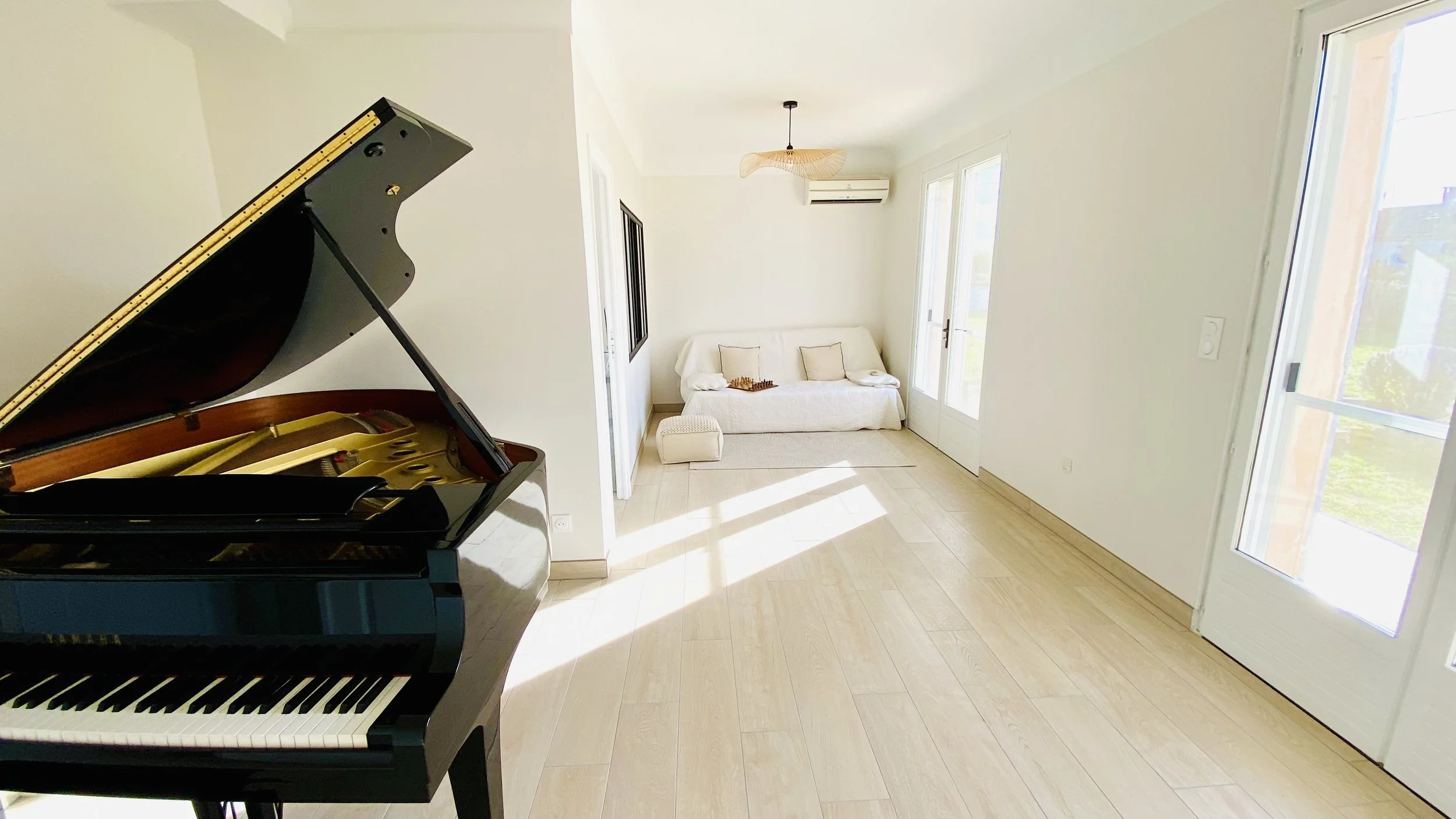 Grand piano in bright music lounge inside Villa Magali Arles holiday villa in Arles Provence