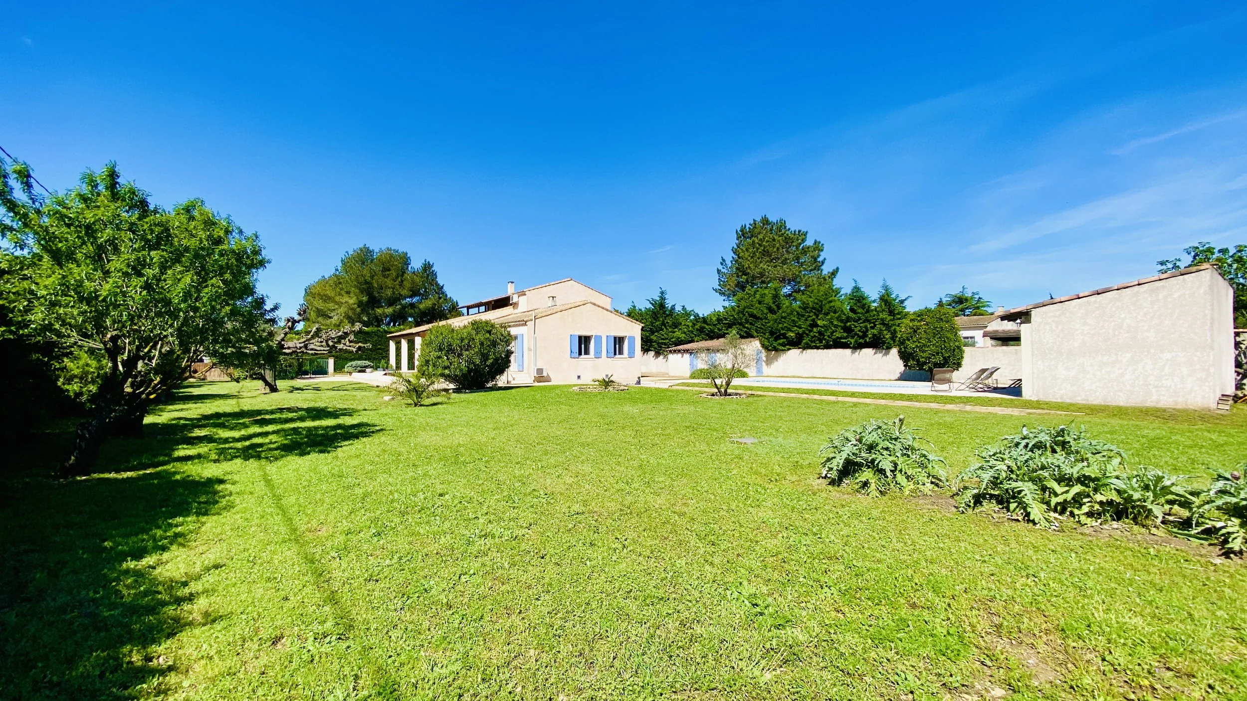 Large green garden surrounding Villa Magali Arles with pool and terrace in Provence