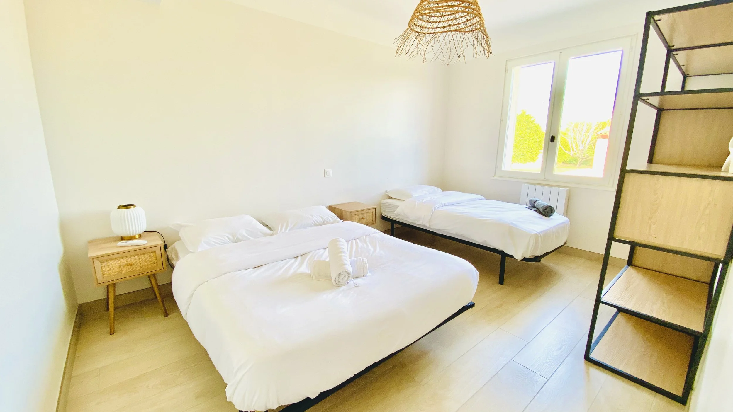 Bright family bedroom with double bed and single bed overlooking the garden at Villa Magali Arles