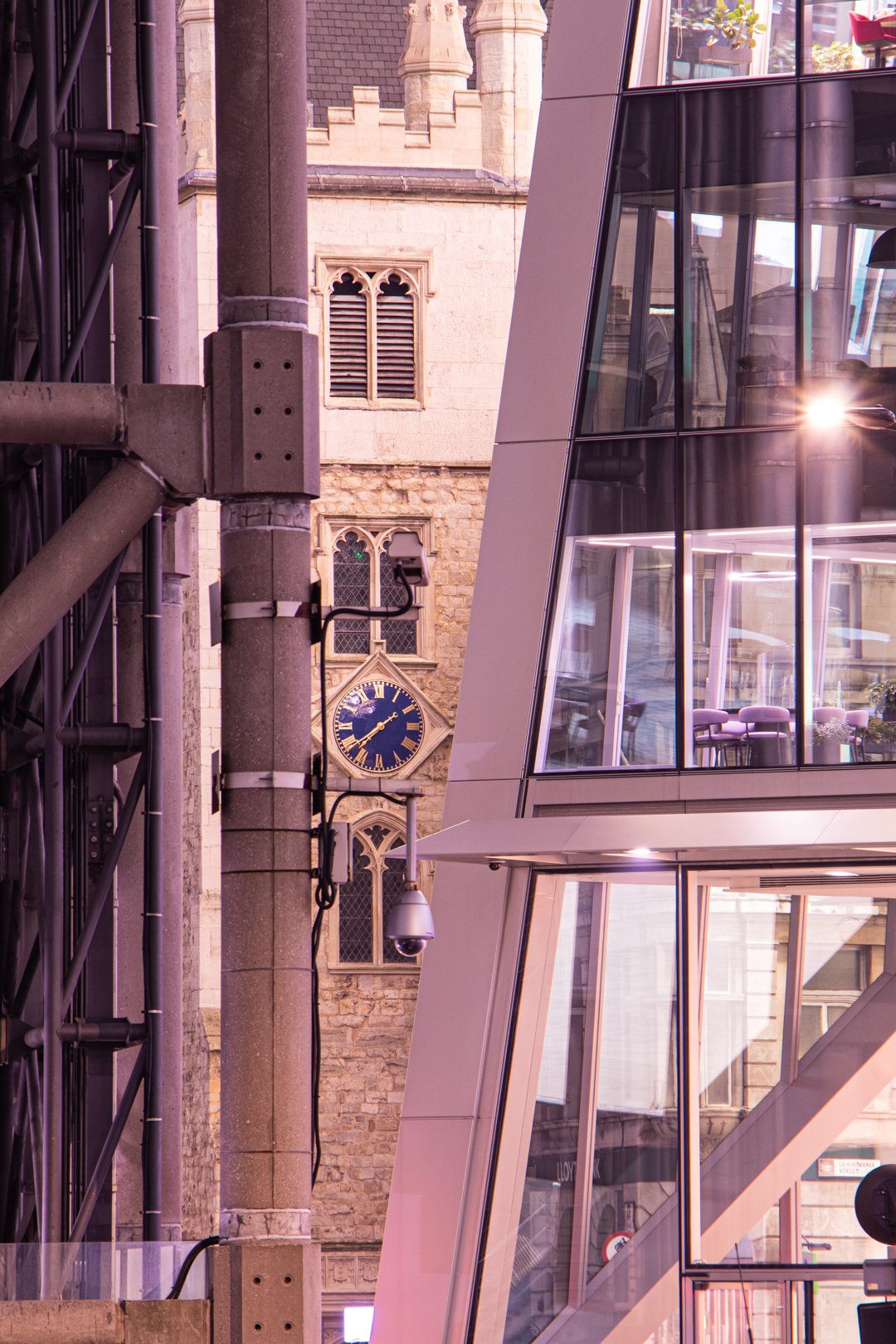 The clock of 15th Century St Andrew Undershaft Church in St Mary Axe peaks out between the frame of the Lloyds Building and the slanted corner of the Scalpel.jpg
