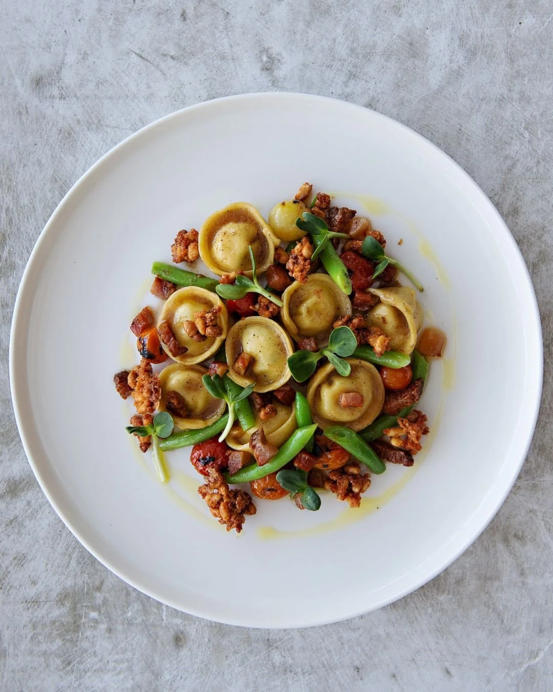 Give this week's stuffed pasta feature a try. We promise you won't regret it.⁠
⁠
Taleggio Fonduta Cappelletti with marinated green beans, confit tomatoes, and spiced pine nuts. Rich, creamy, and packed with flavour, this is one feature you won't want