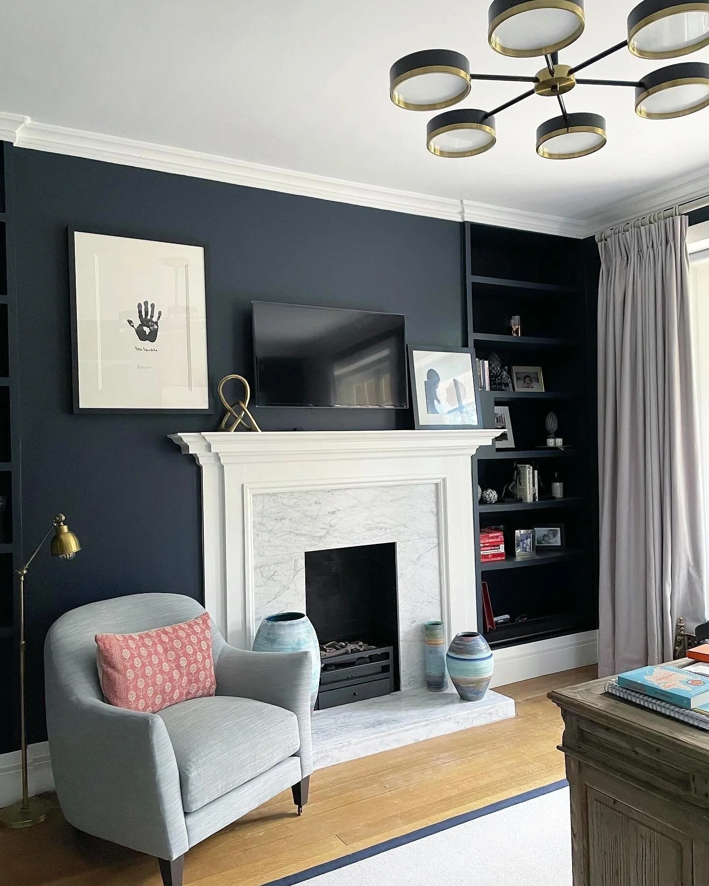 My client had already gone bold on here with the navy walls. However it needed a bit more work to make it all come together. 

A new light fitting, chair and fireplace stone made a big difference, as did some shelf styling and an artwork rehang. 

Sw