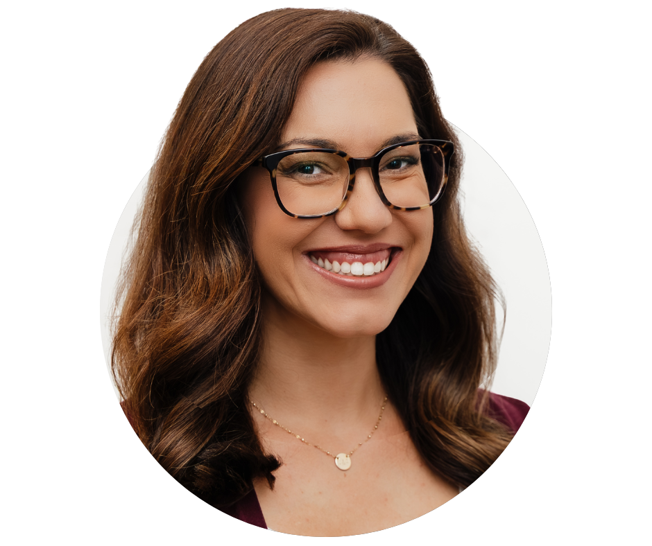 A woman with long, wavy brown hair, wearing glasses, a maroon top, and a gold necklace, smiling against a plain white background.