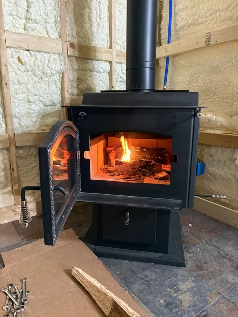 ignited classic black wood stove in the corner of the room