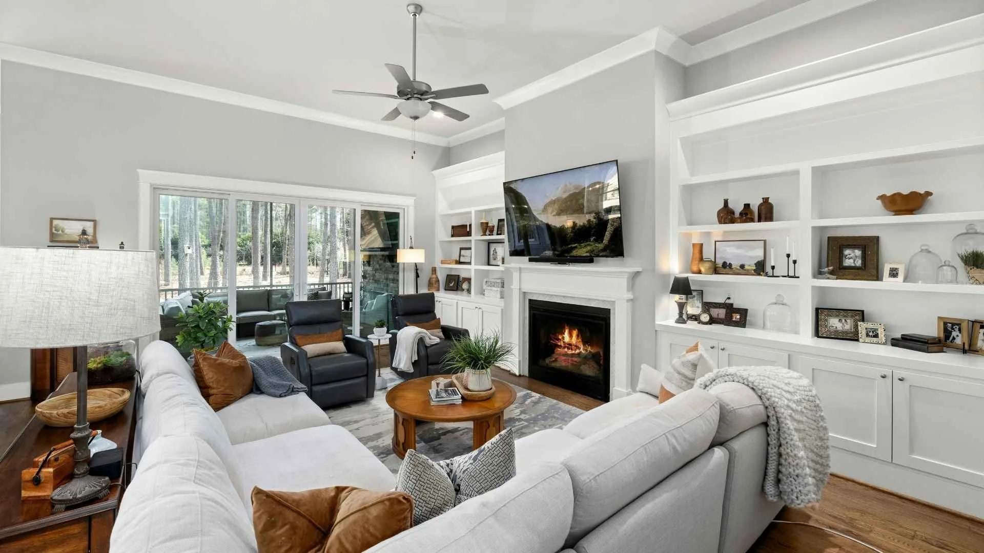 modern living room with white couch, tv on wall and custom shelfing units for decor