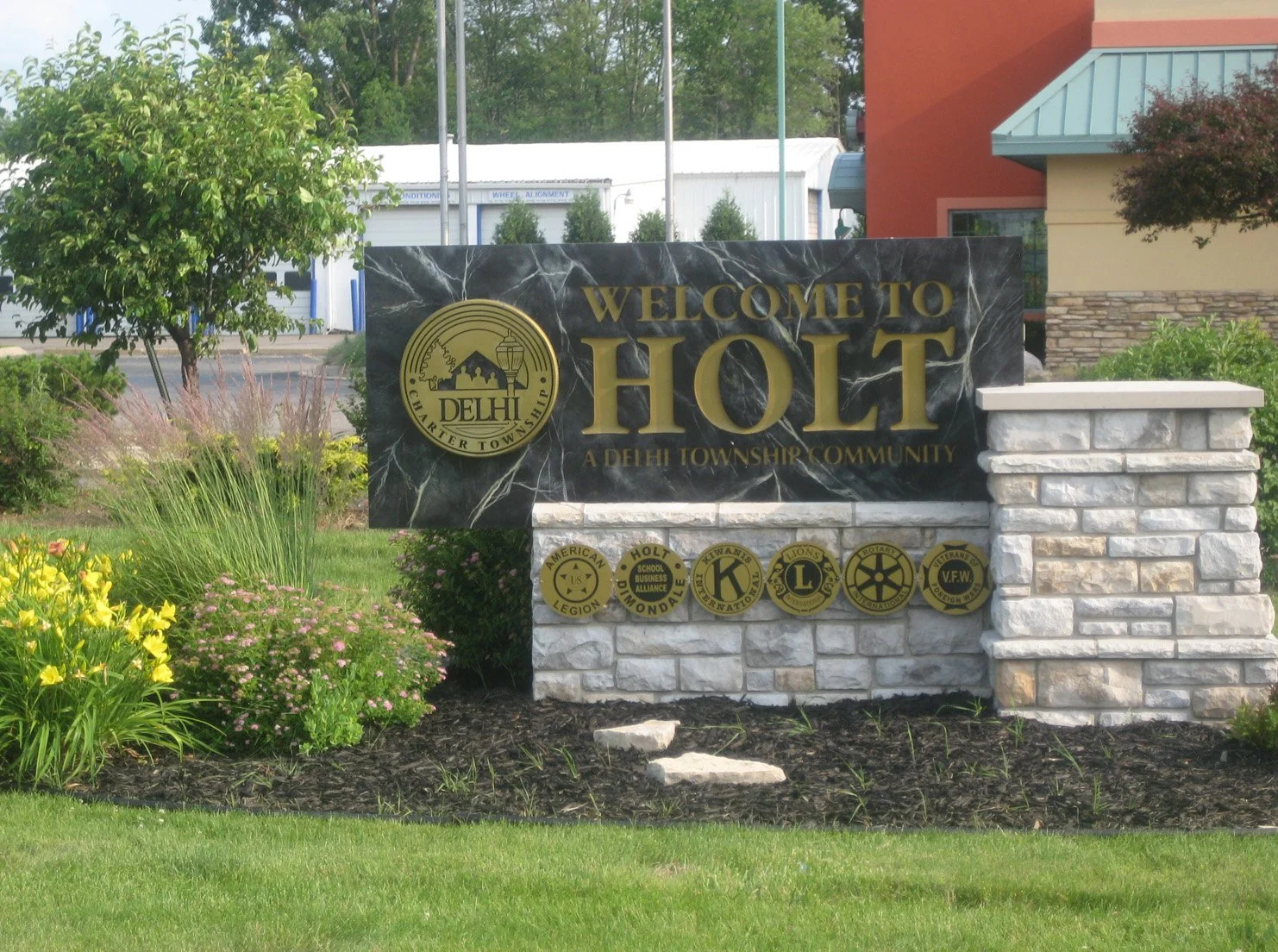 city of holt michigan sign surrounded by greenery