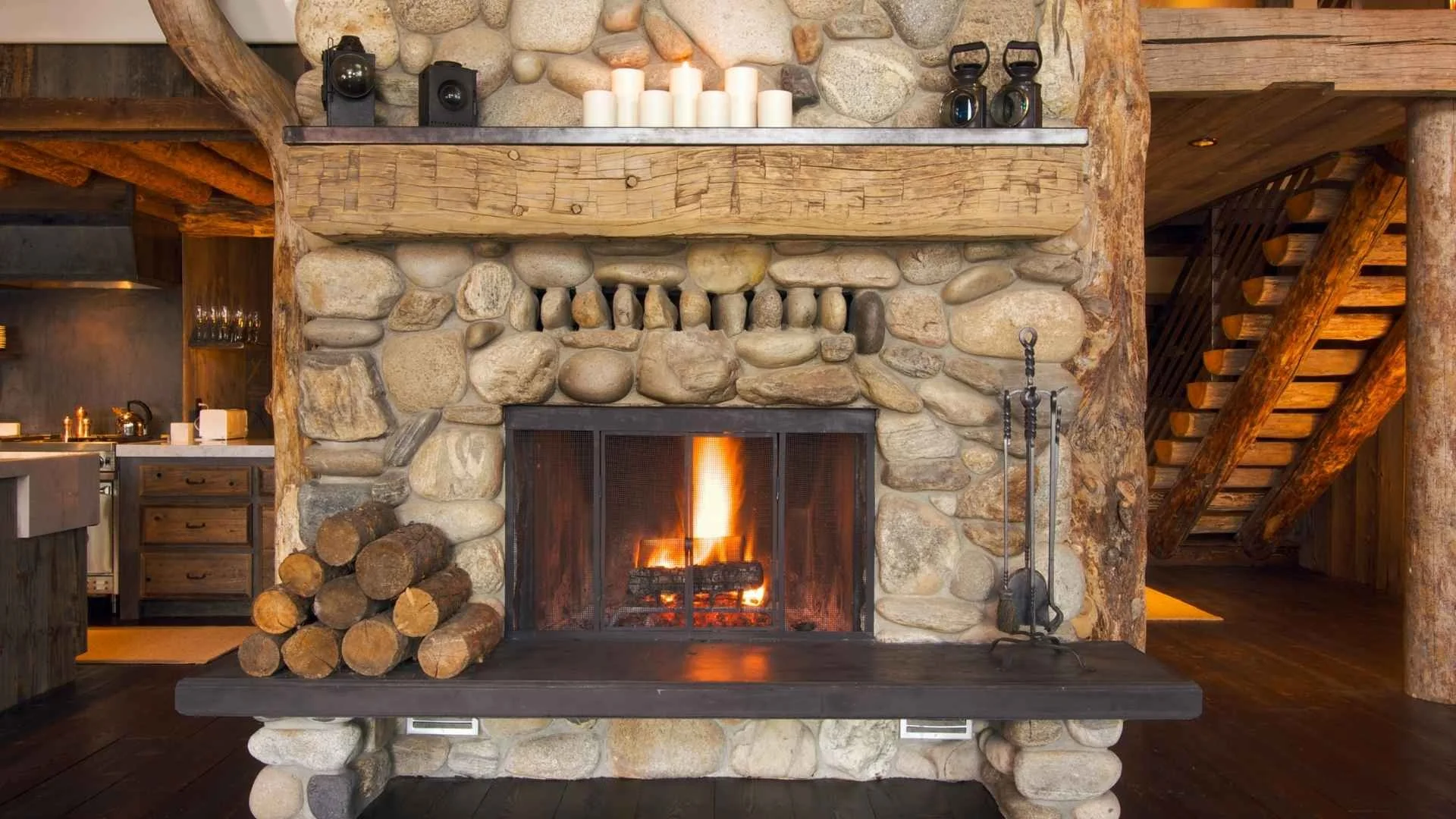 rustic fireplace inside a wood cabin with candles and a wooden frame