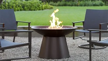 round outdoor fireplace with green grass setting